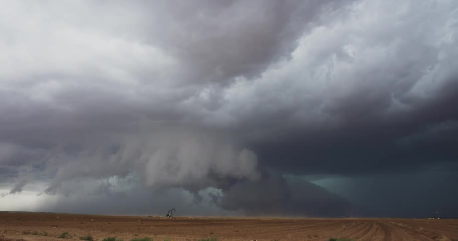 Dark storm clouds are moving over rural farmland