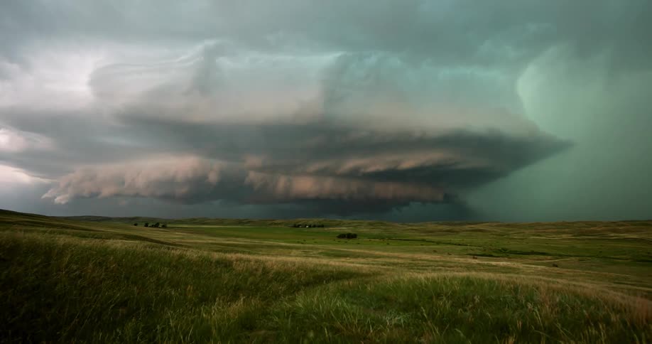 Lightning strikes through dark clouds over a field