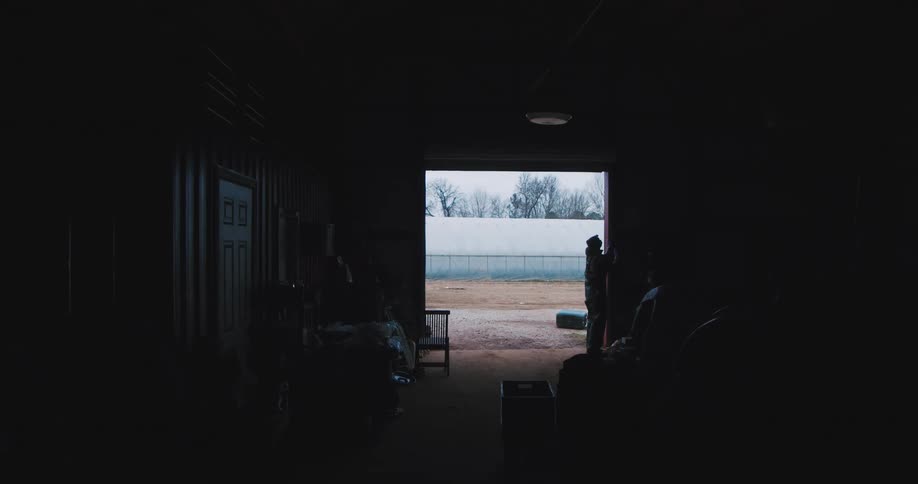 Farmer closes the rolling door to the barn