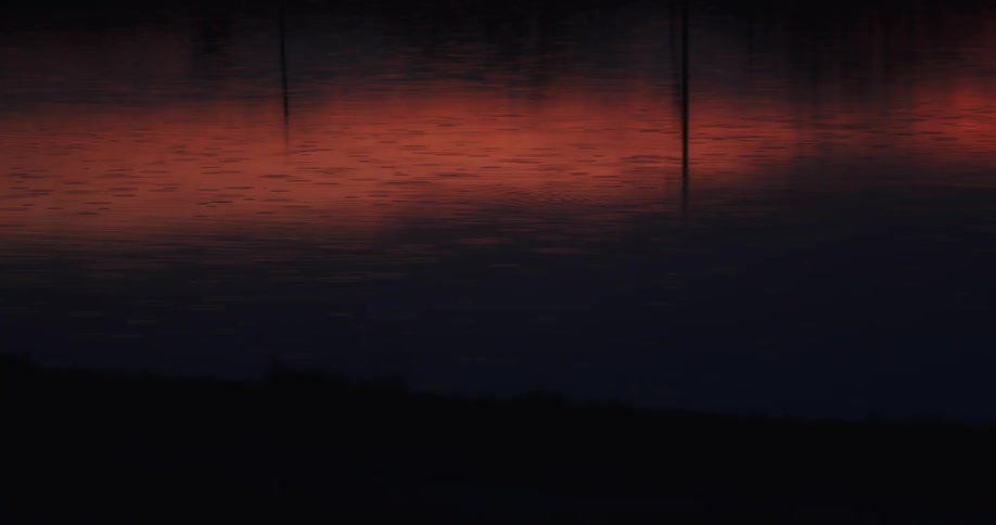Reflection of the red sunset sky on the calm surface of a lake