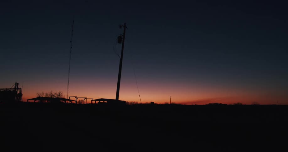 Silhouette of buildings on the countryside under a red sky at evening