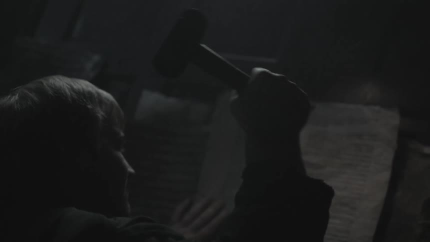 A man hammers a notice into a wall
