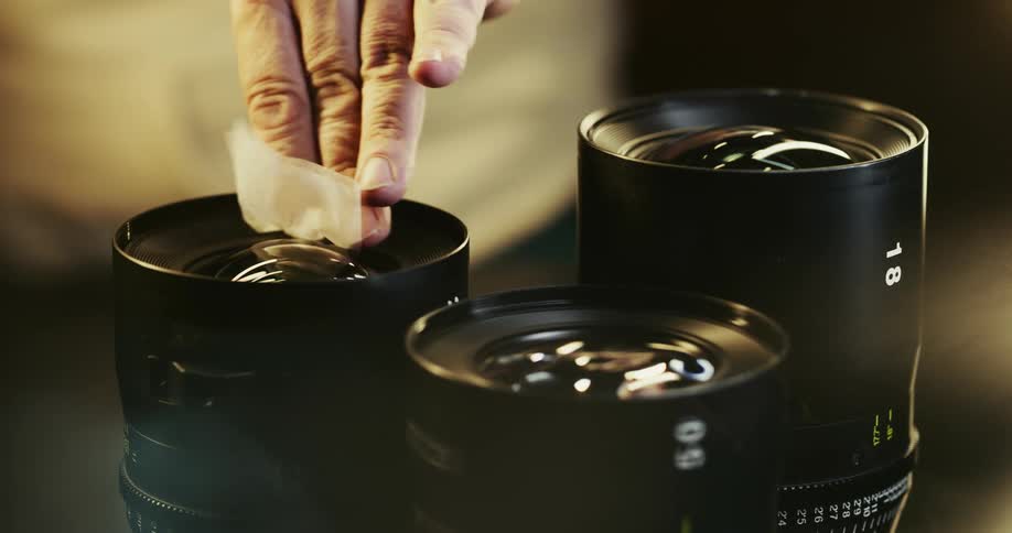 Person wipes glass on camera lenses