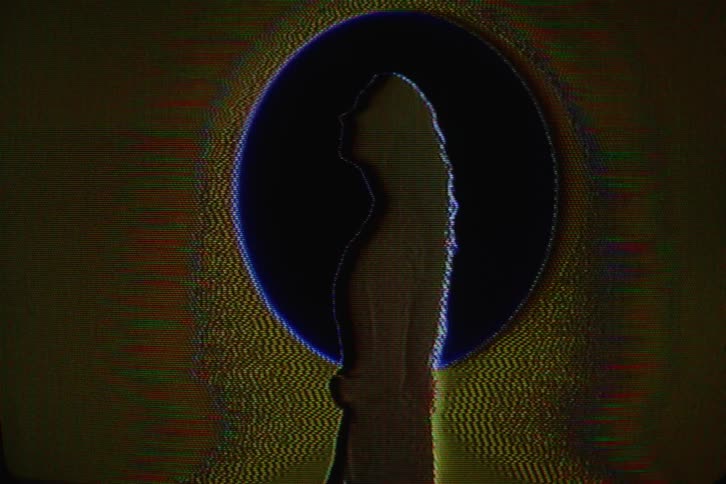 A womans silhouette while she flips her head and hair back