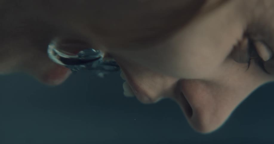 A woman screams with her face partially submerged in water