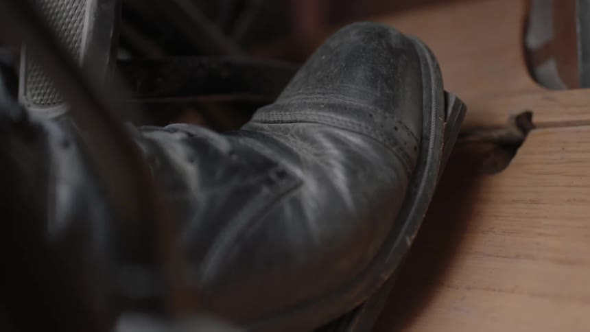 A foot presses down on a vehicle peddle