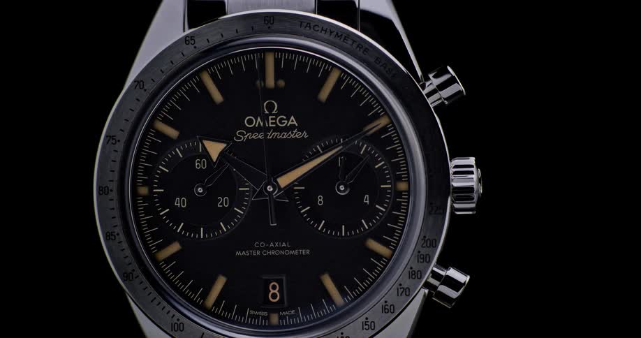 Close up of the dial of a luxury wristwatch against a black background