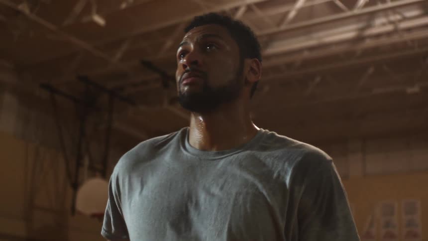 A man who is sweating stands looking off into the distance and then runs away