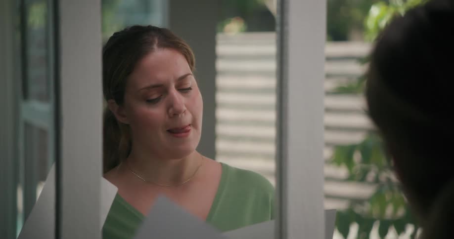 A woman practices and edits a speech in a mirror