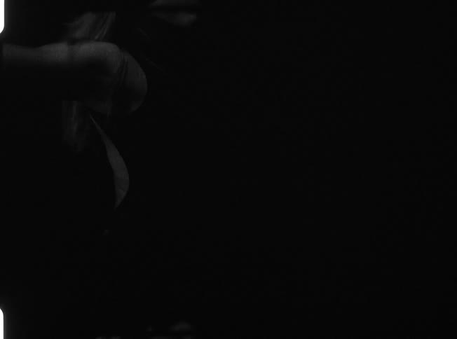 A woman is dancing in a dark area