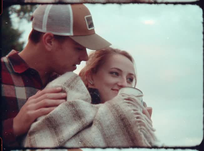 A man and women kiss and smile