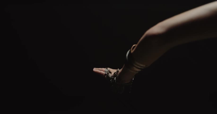 A woman is belly dancing in the dark