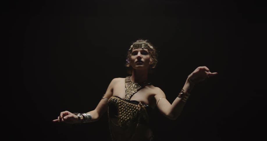 A woman performer moving her hands and arms around and moving her body slowly