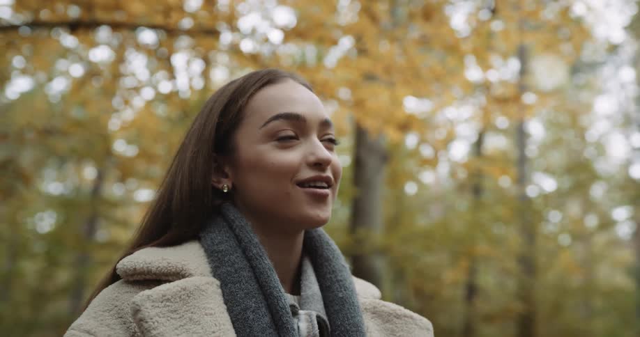 A young man and woman talking in a forested area on a fall day