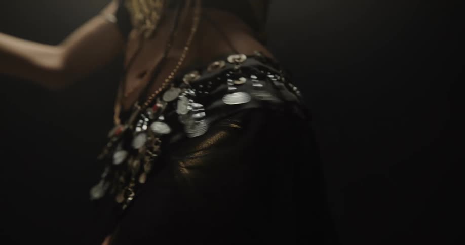 A belly dancer performing against a black background