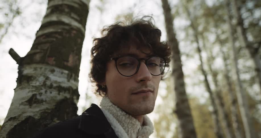 A man leans against the tree