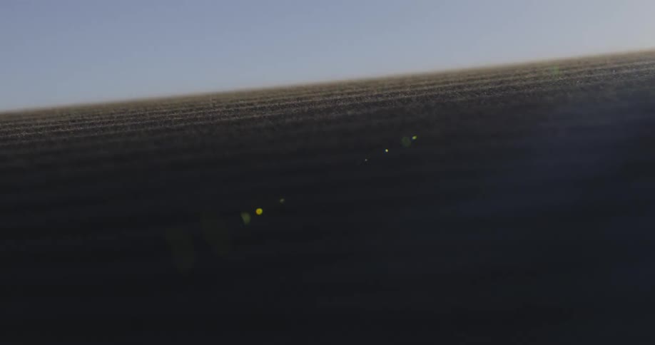 Wind blows sand grains over sand dune in the desert