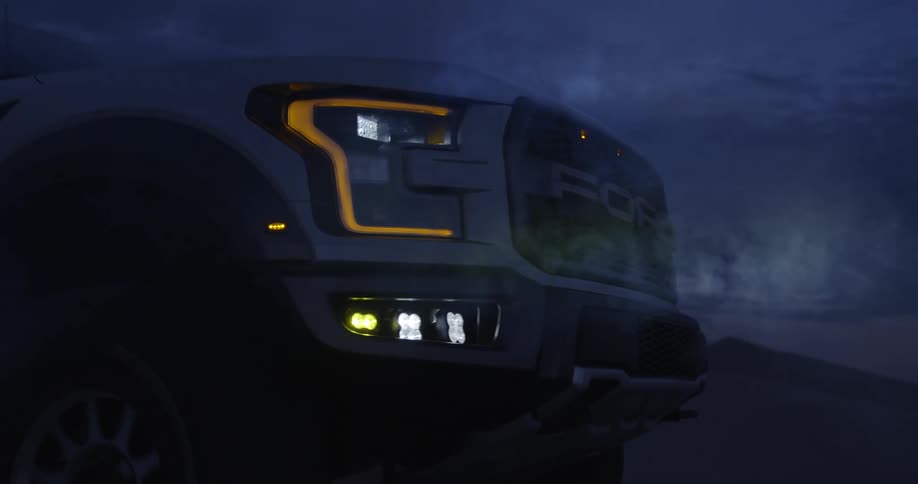 A truck is driving down a desert in the night time