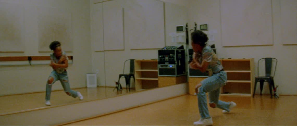 A woman is dancing in front of a mirror by herself