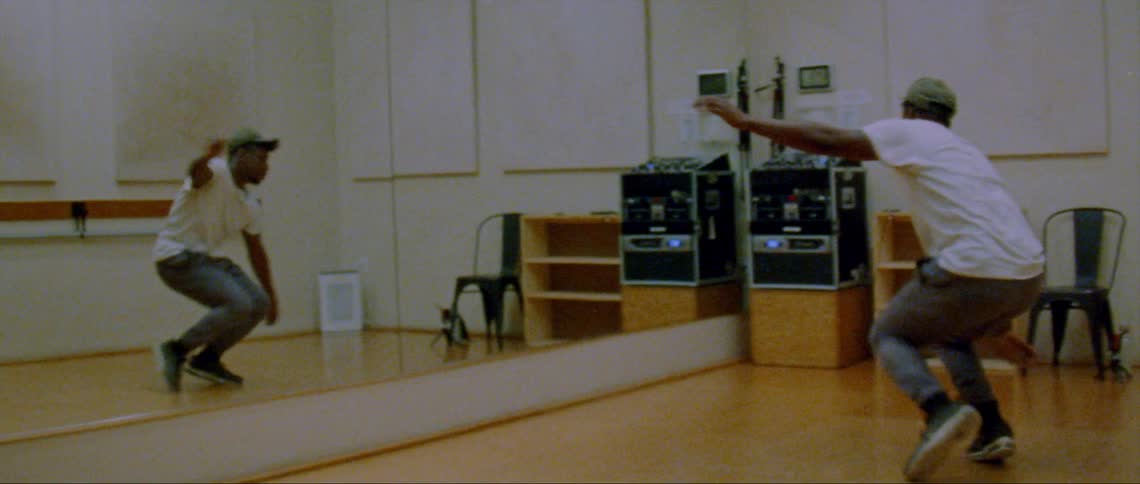 A man is dancing in front of a mirror by himself
