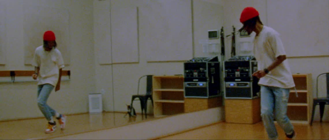 A person is dancing next to a mirror in a room