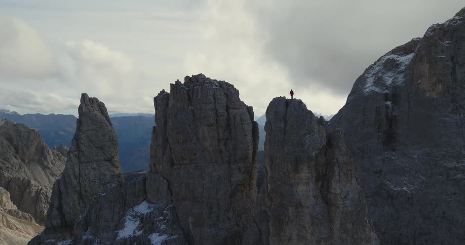 An aerial view of a hiker climbing a steep rock formation in the wilderness