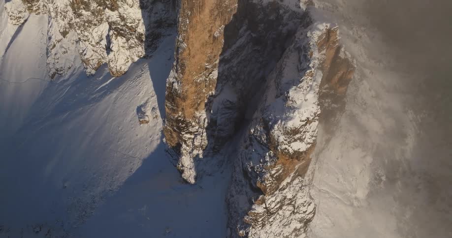 The view is of a cliff that is covered with snow in the winter time