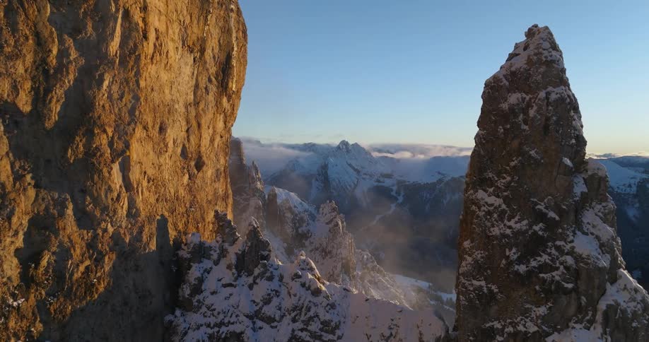 An aerial view of rocky terrain with snow in the evening
