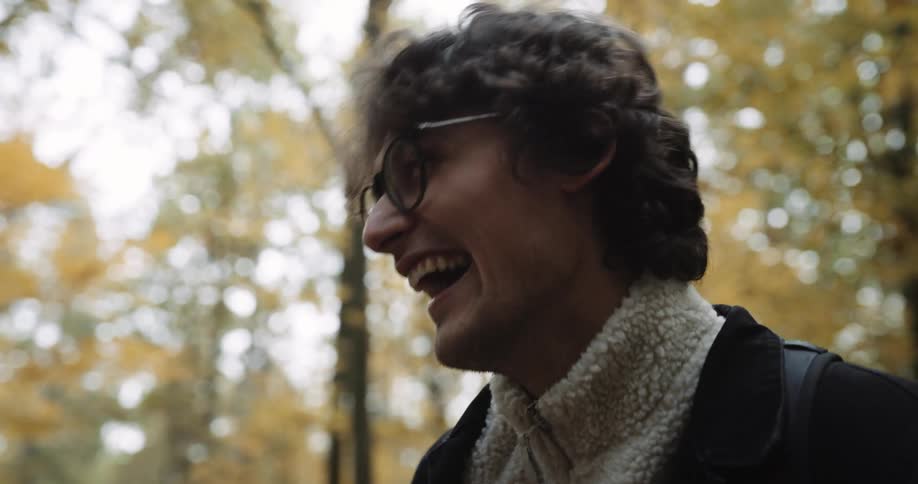 A couple laugh while talking in the woods