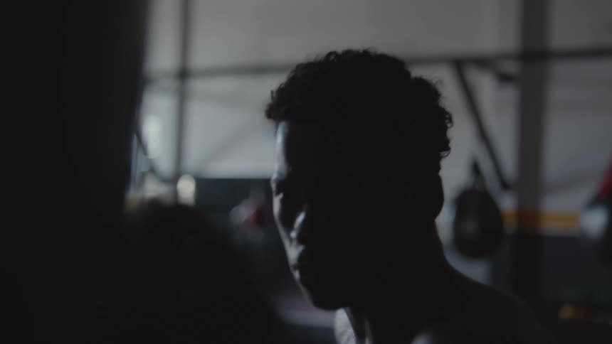 A man is boxing in a gym by himself