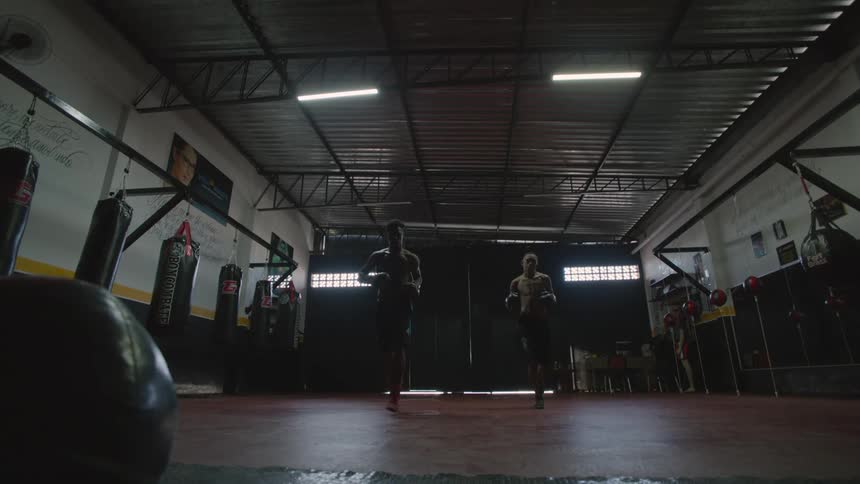Two men are walking inside of a building to box