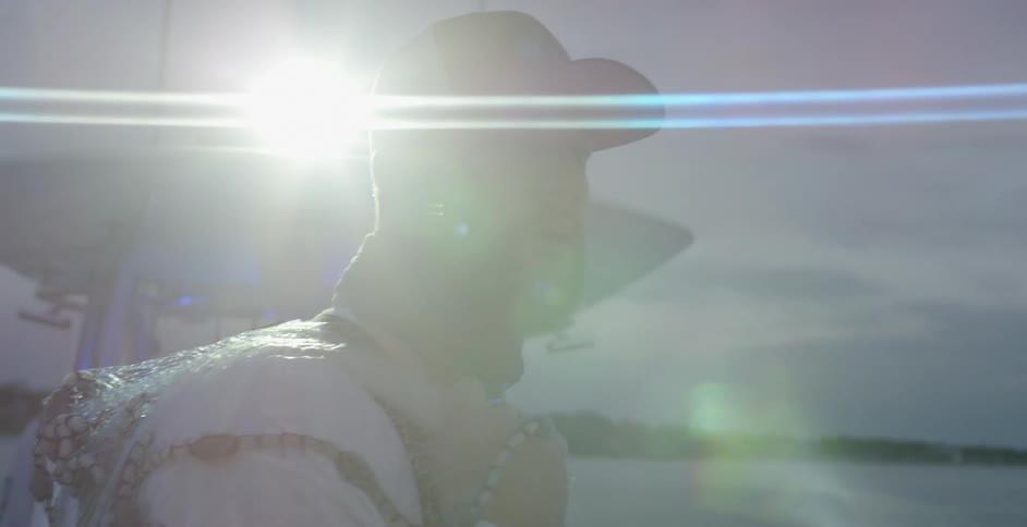 A man standing in front of a bright spotlight on a boat