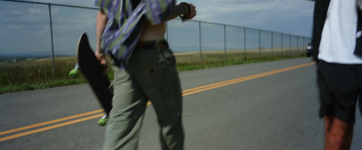 Two young men are returning to their car from a tourist attraction in a rural location on a windy day