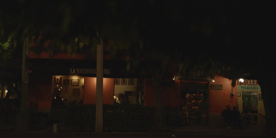Vehicles drive past the store at night