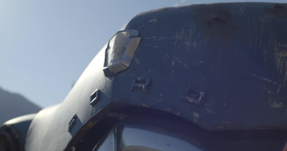 Close up of old ford cars hood and bumper in junkyard