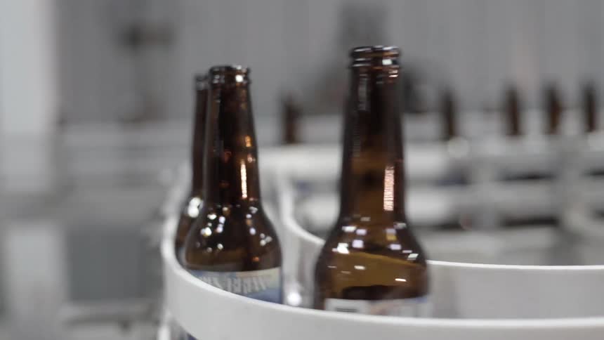 Brown glass bottles moving on a conveyor