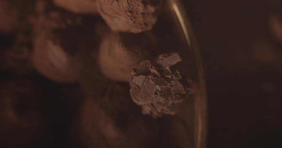 A dozen scoops of chocolate ice cream sit in a large bowl