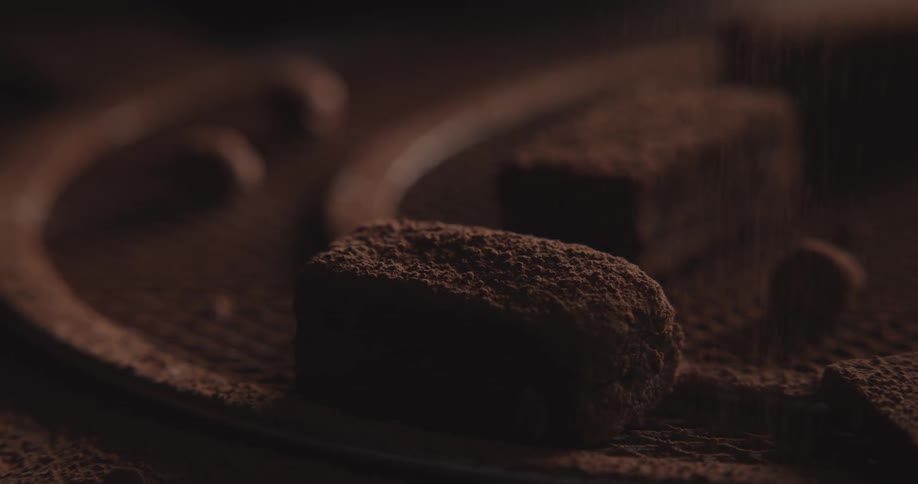 Cocoa powder is dusted onto a chocolate bar