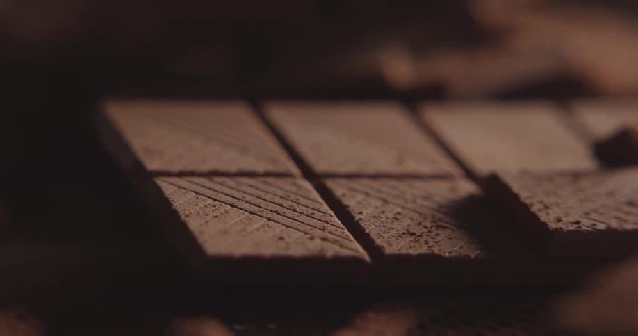 Closeup of a bar of chocolate and cacao powder
