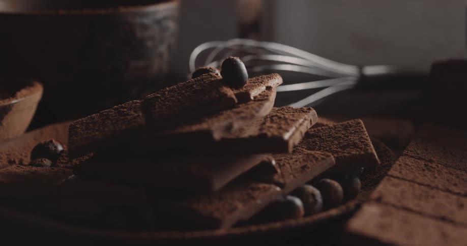 Cocoa nibs rest on top of freshly made chocolate bars