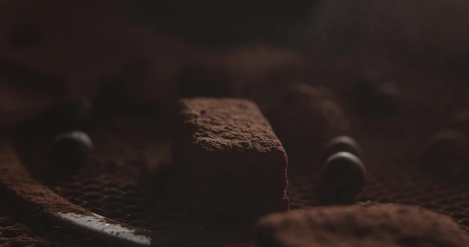 Chocolate sweets being dusted over a tray