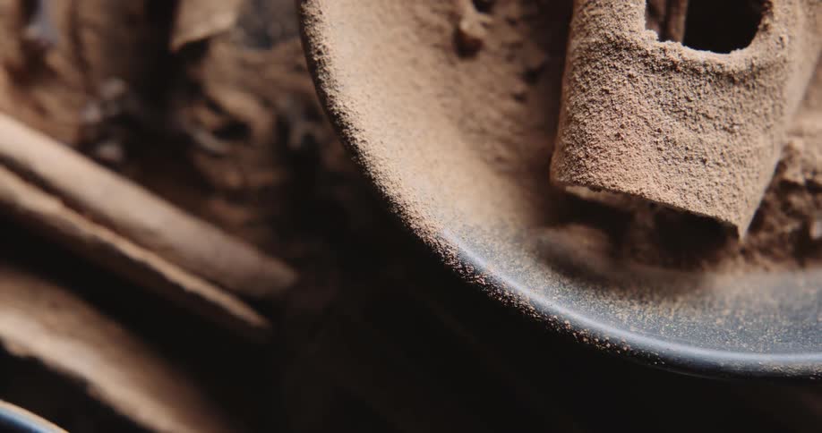 Close up of a bowl of powder and cinnamon sticks