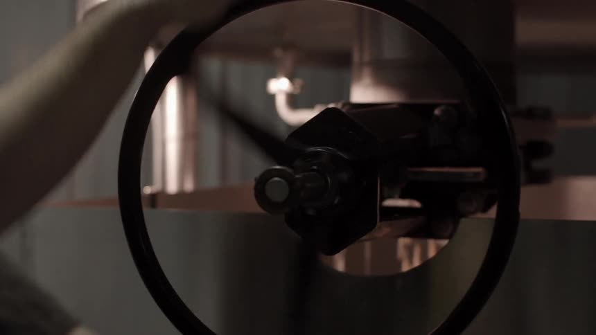 A man spinning a wheel in a factory