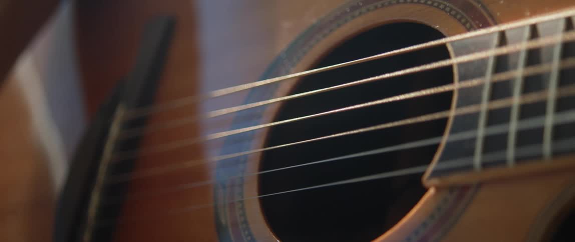 Close up of womans hand playing acoustic guitar