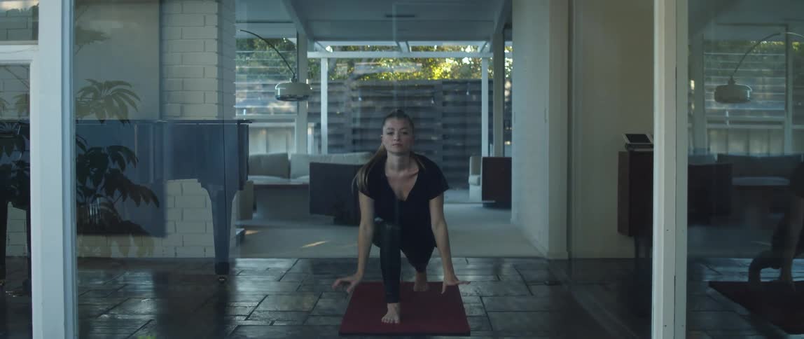 A woman is doing a yoga pose indoors