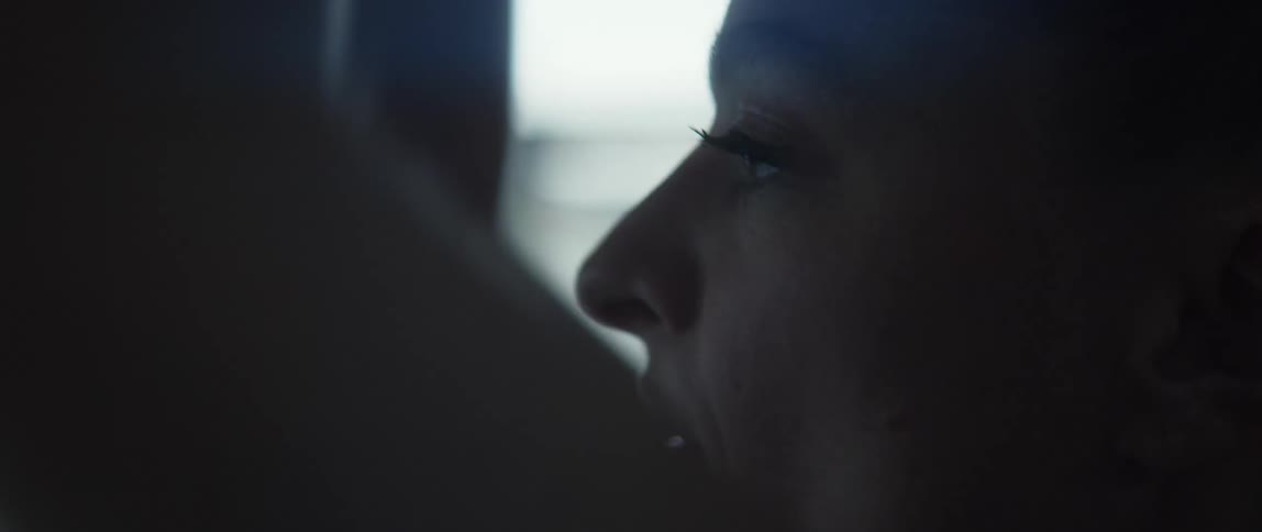 Close up view of the face of a woman as she bends down while exercising