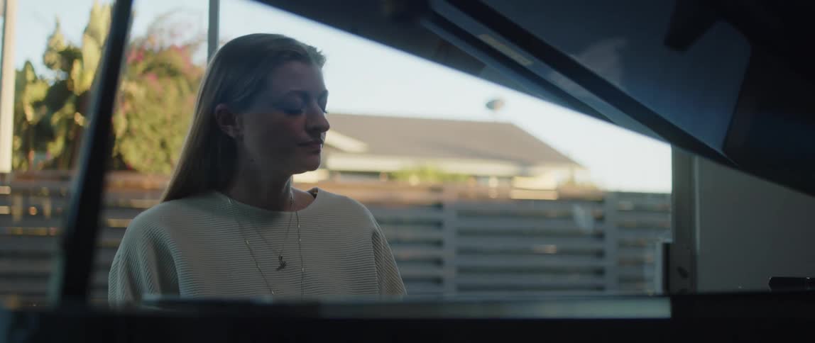 A woman is playing the piano at home