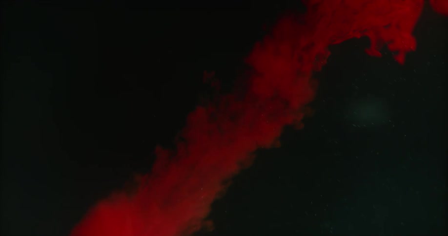 A red ball falls from a red cloud in the darkness leaving a trail of red smoke as it moves