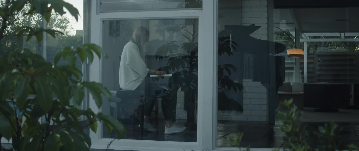 Young woman playing piano near a window at home in the morning