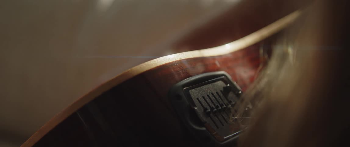 An up close of a woman strumming a guitar